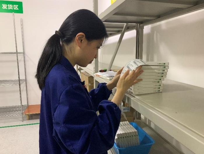 圖為金華市中心醫(yī)院工作人員將追溯二維碼粘貼到醫(yī)療器械包裝盒上。何璇 攝