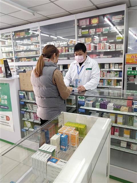 疫情防控時期，魏駿在藥店為顧客提供藥學服務。