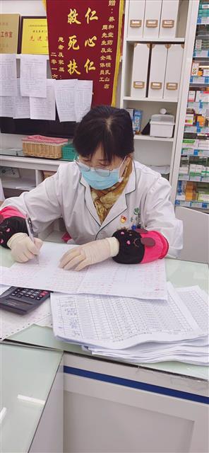 陸萍在統(tǒng)計口罩發(fā)放情況。
