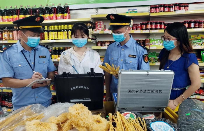 圖為6月21日該局執(zhí)法人員正在一超市檢測食品。