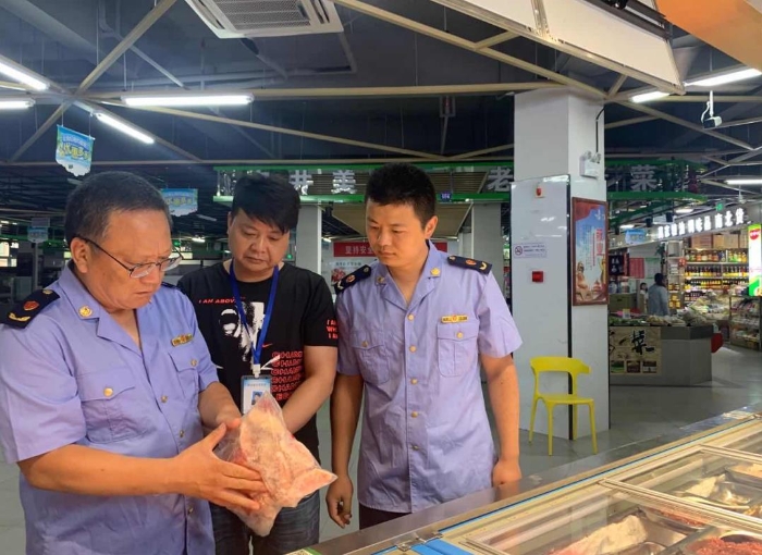 圖為該局執(zhí)法人員在一家農(nóng)貿(mào)市場冷凍食品專柜進(jìn)行檢查。