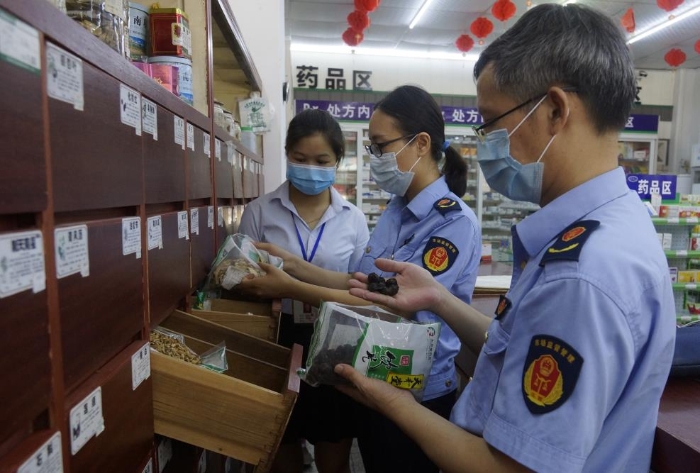 圖為執(zhí)法人員在一家零售藥店檢查中藥飲片。