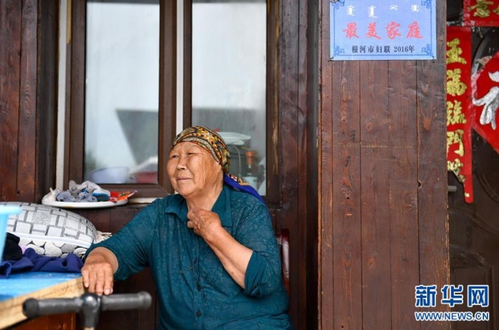 中妮浩坐在位于敖魯古雅鄂溫克族鄉(xiāng)的家門口休息（7月14日攝）。 新華社記者 貝赫 攝
