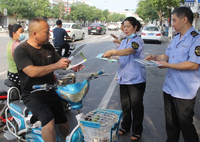 圖為該局執(zhí)法人員在縣城人民路向行人發(fā)放食品安全宣傳材料。