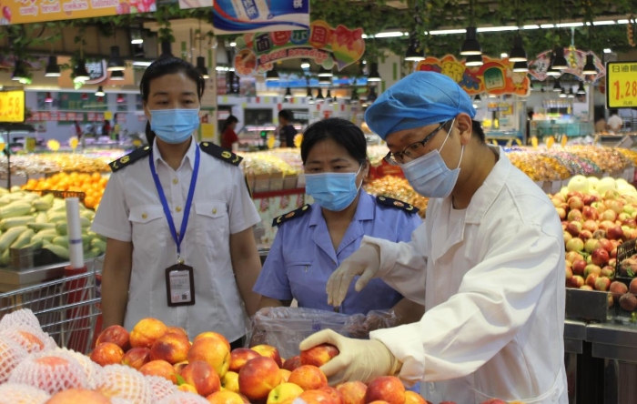 圖為該局執(zhí)法人員在一商場抽取食品樣品送檢。