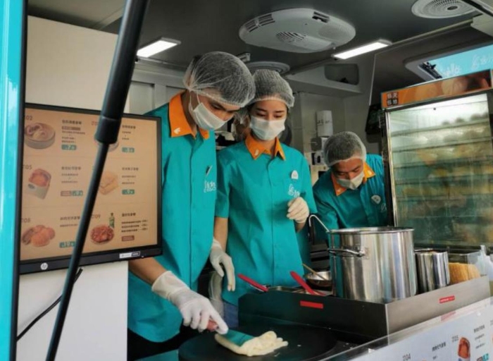 “逸小兔”流動早餐車的店員正在為顧客備餐。新華網發(fā)（熊多多 攝）