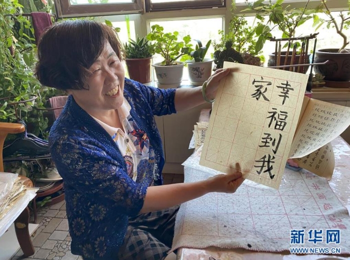 袁秀梅在自家書房寫下“幸福到我家”幾個(gè)字（8月18日攝）。 新華社記者 汪亞 攝