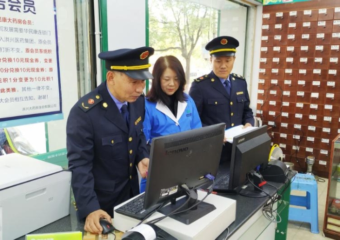 圖為執(zhí)法人員在查看藥店處方藥銷(xiāo)售臺(tái)賬。
