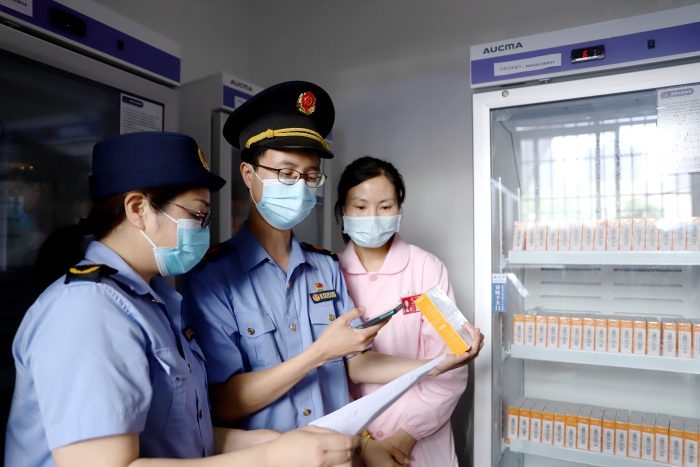 圖為5月21日該局執(zhí)法人員正在對市體育館內(nèi)接種點的疫苗進行檢查。