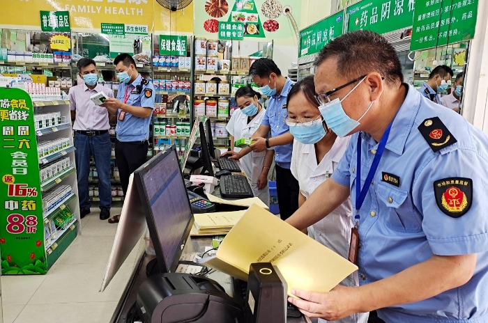 圖為6月20日，該局執(zhí)法人員正在一家零售藥店檢查銷售退燒、止咳、抗病毒、抗菌類藥品實名登記和信息報告情況。