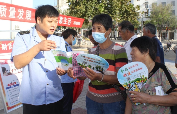 圖為執(zhí)法人員向群眾宣講食品安全知識。
