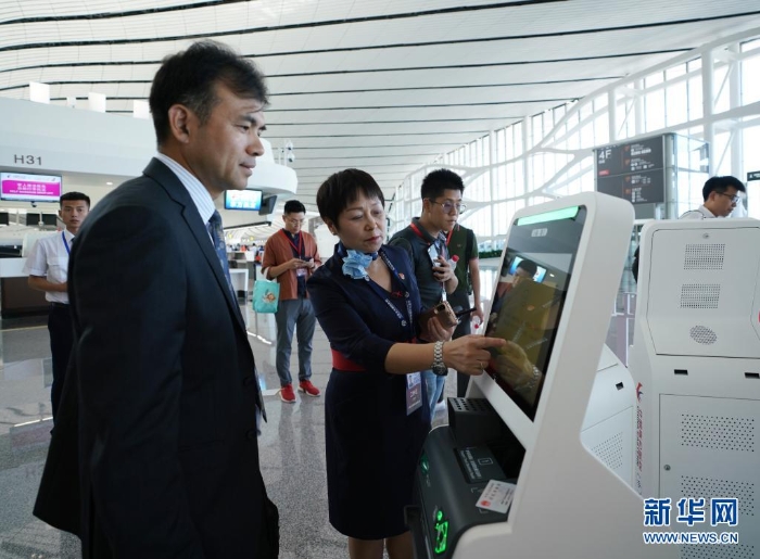 中國東方航空公司工作人員（前左二）在指導(dǎo)乘客通過“人臉識別”辦理值機(jī)手續(xù)（2019年9月25日攝）。新華社記者 鞠煥宗 攝