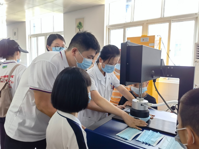 圖為技術(shù)人員在講解口罩的檢驗(yàn)方法和原理。（喻燦華 攝）