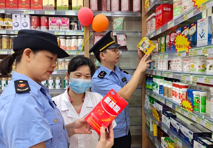 圖為7月26日執(zhí)法人員檢查保健食品標簽標識。