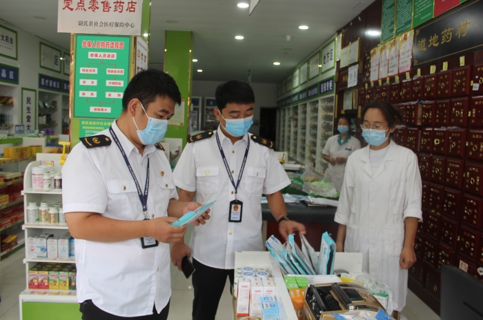 圖為執(zhí)法人員在一家藥店檢查口罩產(chǎn)品質(zhì)量。