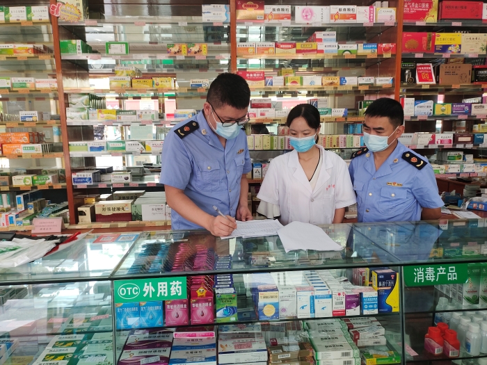 圖為監(jiān)管人員在一家藥店核對(duì)退燒、抗病毒等藥品銷售登記本。