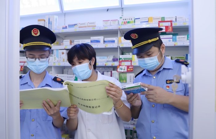 圖為9月13日執(zhí)法人員在一家藥店查看網(wǎng)絡(luò)藥品銷售登記情況，并核對處方藥處方單。