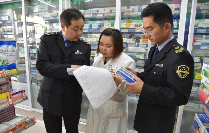圖為該局執(zhí)法人員正在一家藥品零售企業(yè)檢查質(zhì)量管理體系文件是否執(zhí)行到位。