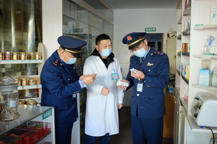 圖為執(zhí)法人員在一家藥店檢查其經(jīng)銷的藥品外包裝上標簽是否規(guī)范，并核對相關(guān)購銷登記臺賬的信息是否合規(guī)。