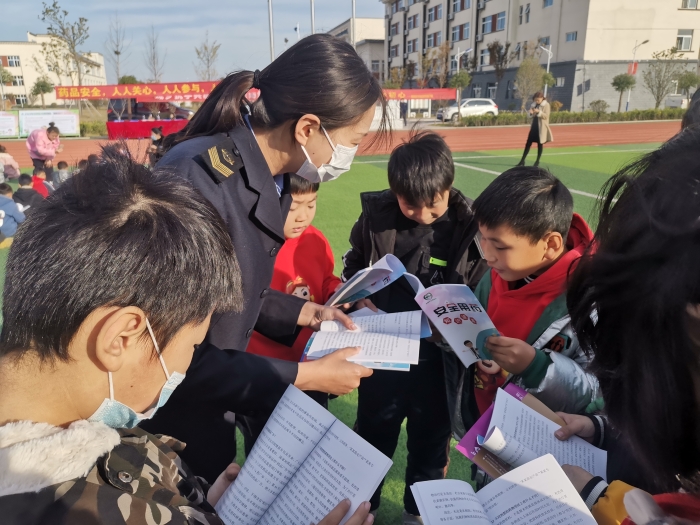 圖為工作人員為小學(xué)生講解安全用藥科普知識。