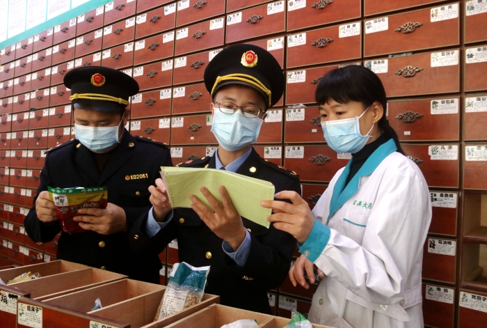 圖為11月24日執(zhí)法人員對一家藥店檢查中藥飲片。