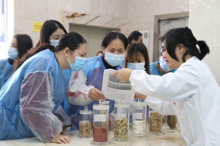 圖為工作人員為市民代表講解中藥材真?zhèn)舞b別知識(shí)。