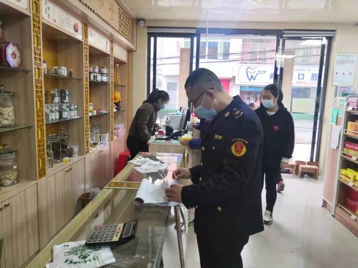 圖為執(zhí)法人員在一家藥店查看登記臺賬。