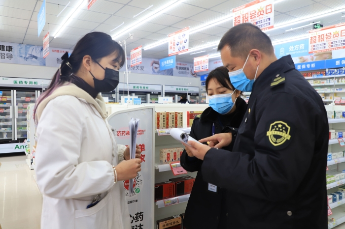 圖為1月11日執(zhí)法人員在一家藥店檢查疫情防控情況。