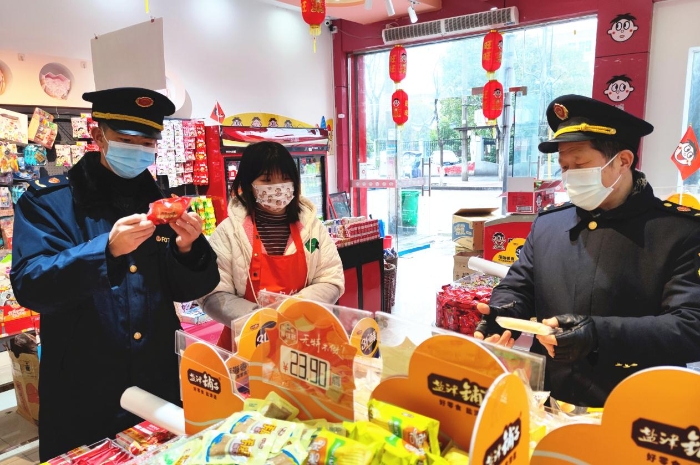 圖為執(zhí)法人員在學(xué)校周邊超市檢查兒童食品質(zhì)量。