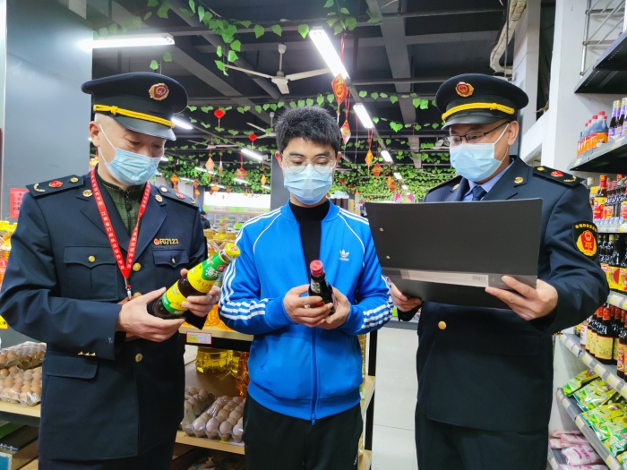 圖為執(zhí)法人員在一家超市檢查調(diào)味品質(zhì)量。