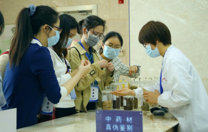 圖為工作人員為市民代表講解中藥材鑒別知識(shí)。
