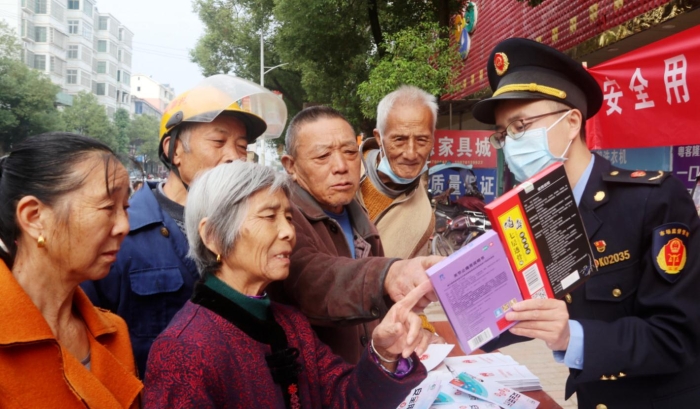 圖為該局工作人員在羅坊鎮(zhèn)集鎮(zhèn)向消費(fèi)者講解如何識(shí)別假劣藥品。