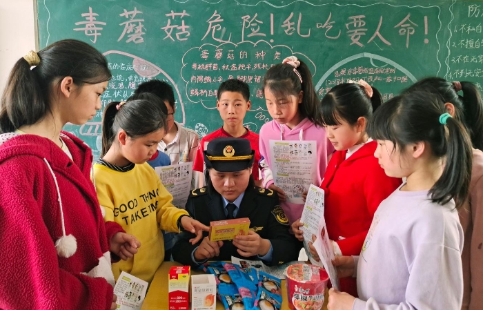 圖為該縣市場監(jiān)管局嶺背分局工作人員在嶺背大窩小學(xué)向?qū)W生講解如何鑒別假冒偽劣食品藥品。王雨林 段丁長 攝