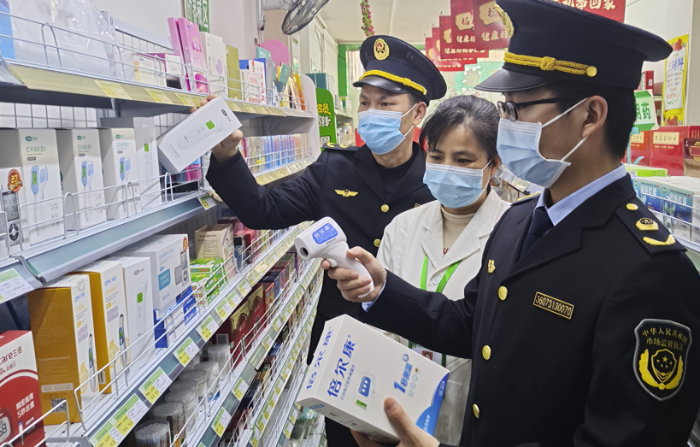 圖為執(zhí)法人員在一家藥店檢查額溫槍。