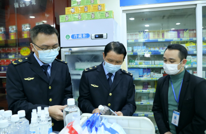 圖為執(zhí)法人員檢查口罩、酒精等防疫物資。