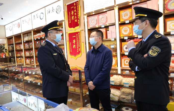 秦繼紅（左一）在中藥材市場(chǎng)聽(tīng)取長(zhǎng)沙市、雨花區(qū)市場(chǎng)監(jiān)管局負(fù)責(zé)人介紹相關(guān)情況。（喻燦華 攝）