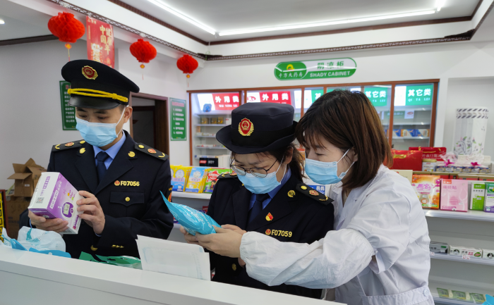 圖為執(zhí)法人員在藥店檢查疫情防控用品質(zhì)量。