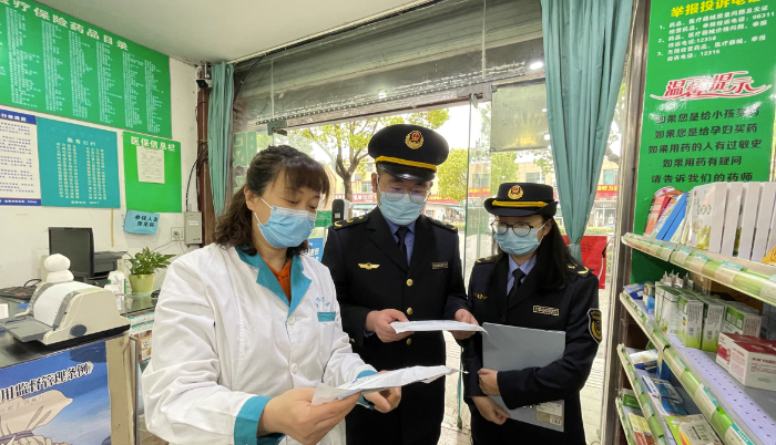 圖為執(zhí)法人員在一家藥店檢查疫情防控情況。