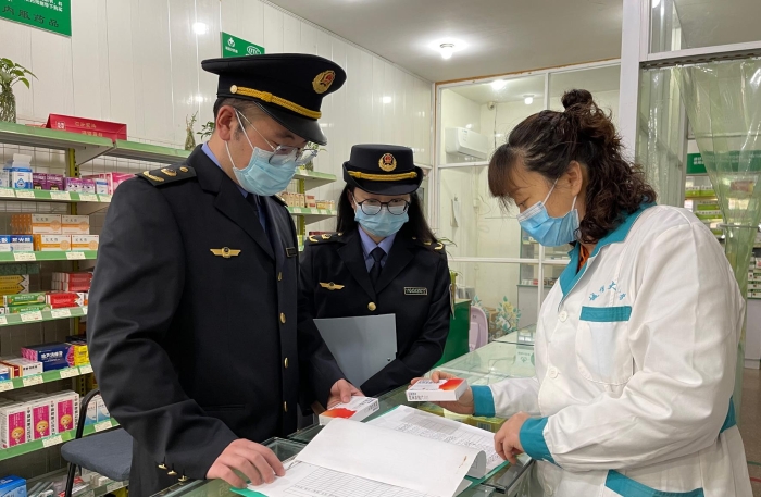 圖為執(zhí)法人員正在一家藥店檢查藥品信息登記情況。