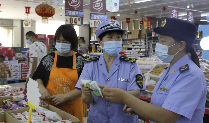 圖為執(zhí)法人員在一家商場食品專柜進行執(zhí)法檢查。