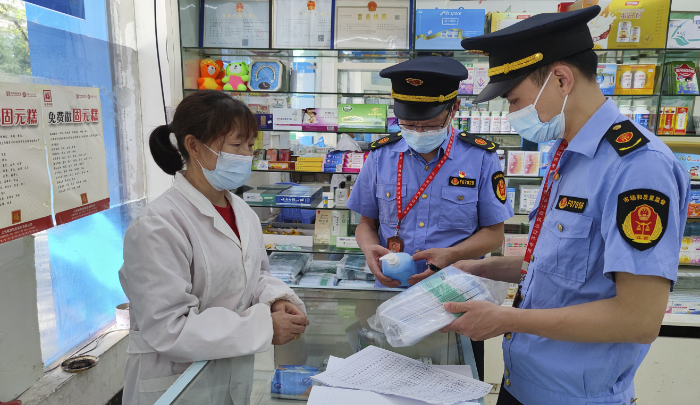 圖為執(zhí)法人員在藥店檢查防疫藥品價格。