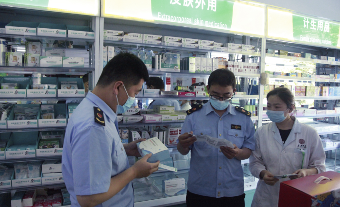 圖為青州市市場監(jiān)管局執(zhí)法人員在一家藥店檢查抗原檢測試劑盒質(zhì)量。