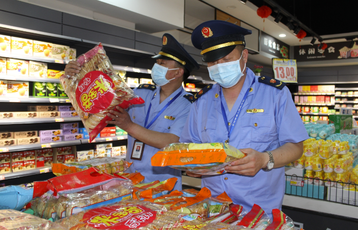 圖為該局執(zhí)法人員在一家農(nóng)村超市查看食品包裝。