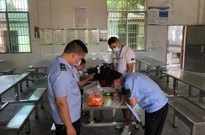 圖為該局執(zhí)法人員在一家學校食堂檢查食品儲存情況。