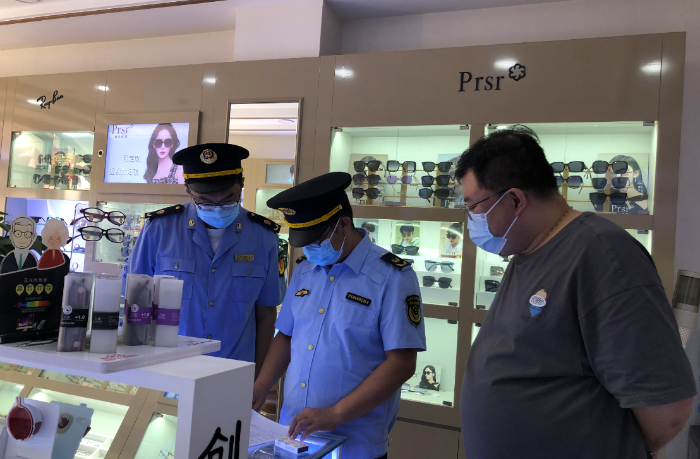 圖為第四分局執(zhí)法人員在一家眼鏡店查看進貨查驗記錄和銷售記錄。
