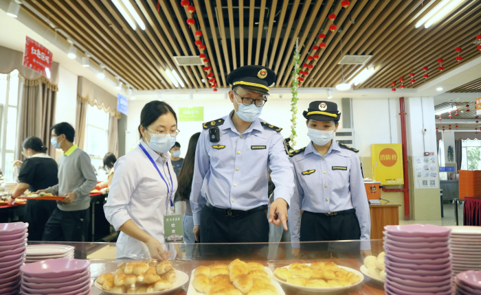 圖為南寧市市場監(jiān)管部門工作人員對大學自助餐廳菜品進行現場檢查。