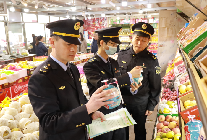 圖為武清區(qū)市場監(jiān)管局執(zhí)法人員在農(nóng)貿(mào)市場檢查食品是否在保質(zhì)期內(nèi)。