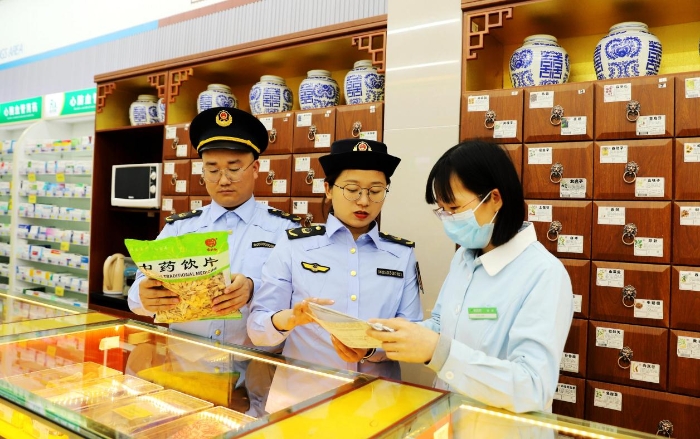 圖為4月25日，執(zhí)法人員在對一家零售藥店的中藥飲片進(jìn)行檢查。