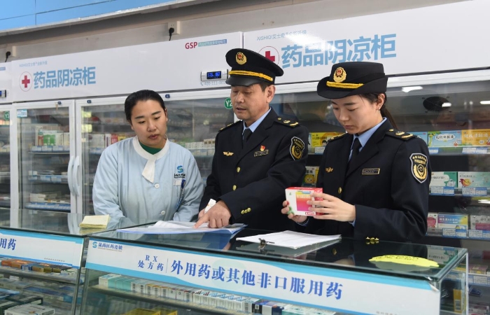 圖為執(zhí)法人員在一家藥品經(jīng)營企業(yè)檢查藥品采購和陰涼藥品儲存記錄情況。