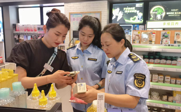 圖為該局執(zhí)法人員在一家化妝品專營店開展檢查并指導工作人員操作化妝品監(jiān)管APP。
